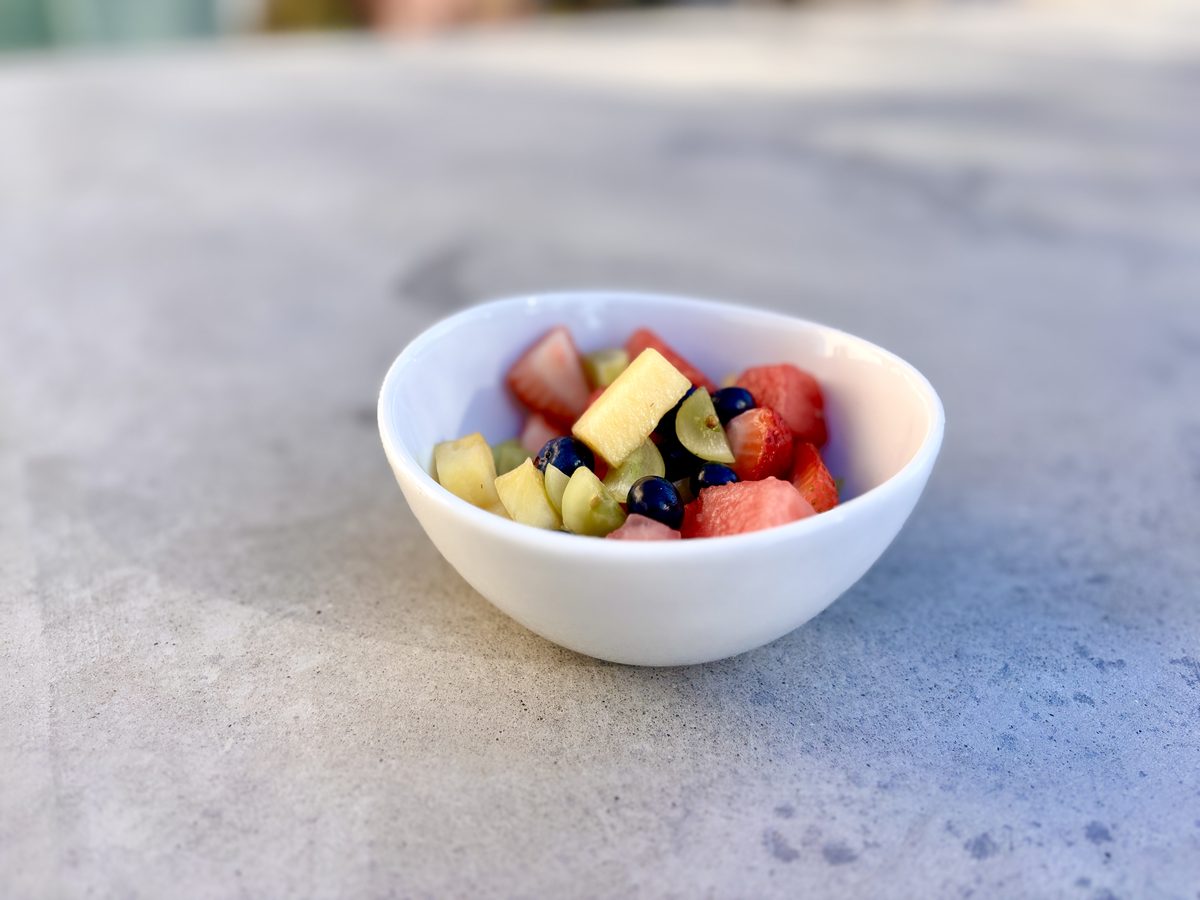 a small white bowl of chopped fruit salad — watermelon, pineapple and blueberries