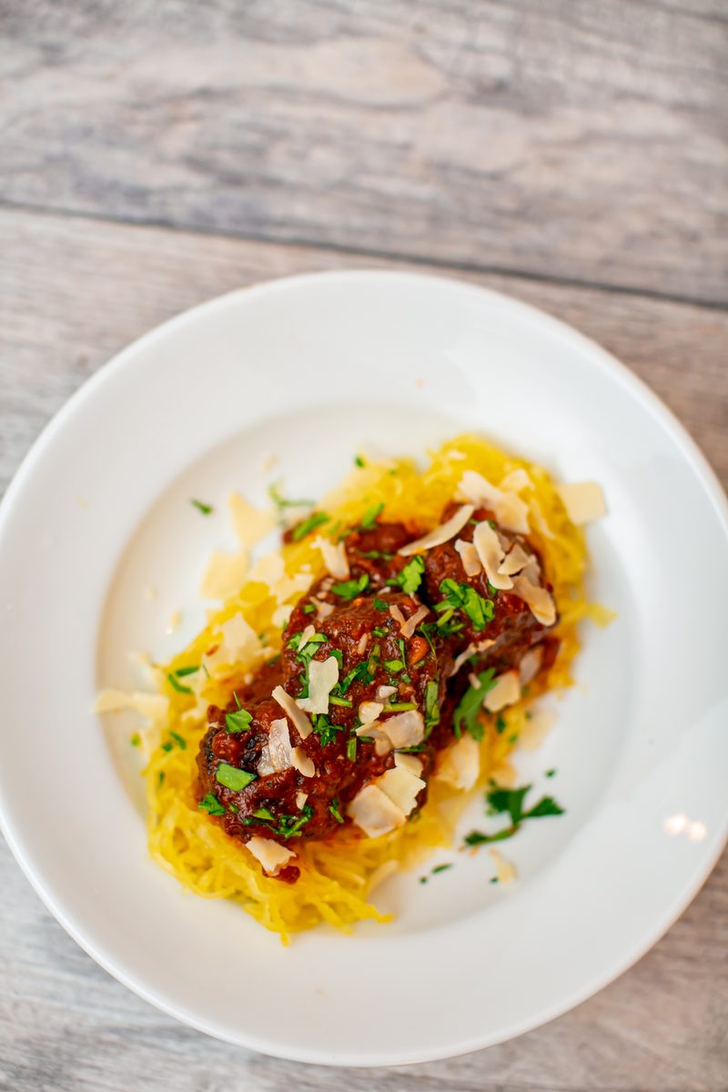 Closer overhead shot of the same plate of spaghetti squash strands under a chunky red sauce (texture reads like a meat ragu but no